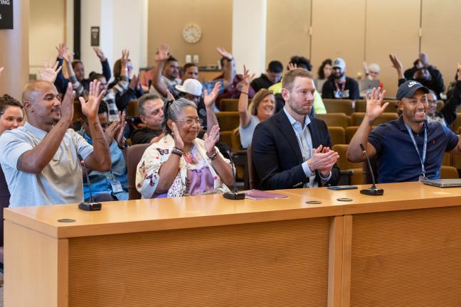 Community members with lived experience (from left) Shane Dorn, Lore Vences and Adam Auler, and the Office of Consumer Engagement supervisor Deandre Kenyanjui tell the Board their stories of their road to recovery. 