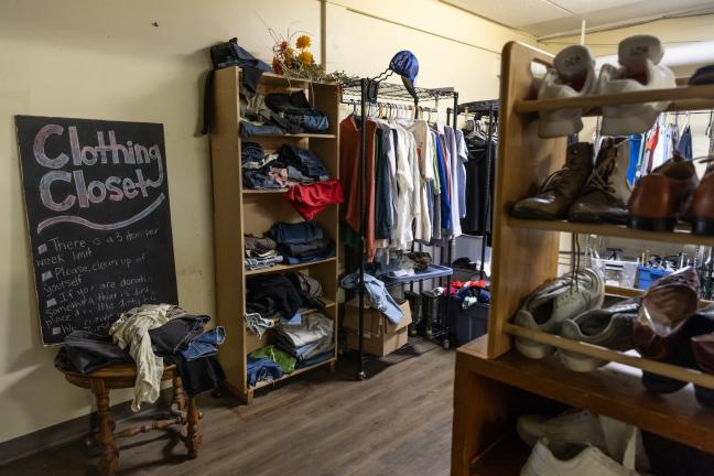 Photo of a room with racks of clothing and shoes.