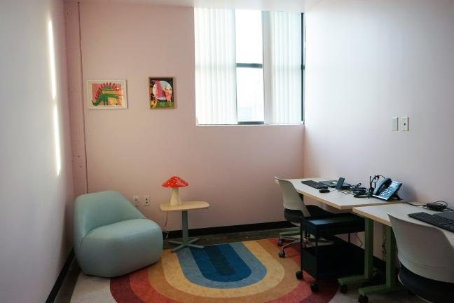 Photo of an office with colorful art and a rainbow rug.