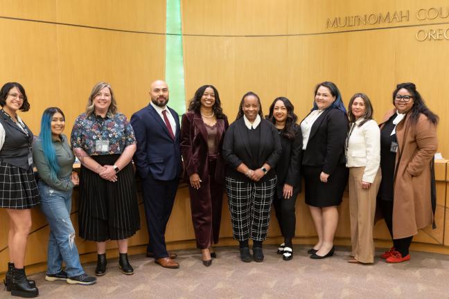 Program staff pose in front of the Board room