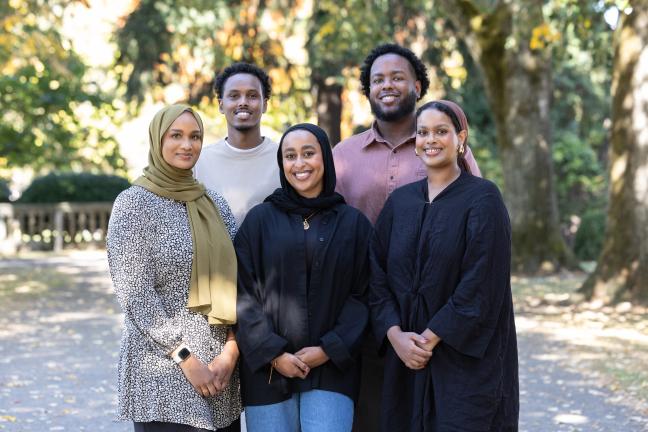 Group of people smile in a park.