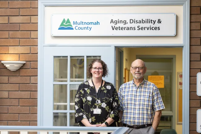 Multnomah County’s Senior Health Insurance Benefits Assistance (SHIBA) program volunteer Bob Earnest takes photo with the Department of County Human Services’ Carisa Dickson, who heads up the SHIBA program.