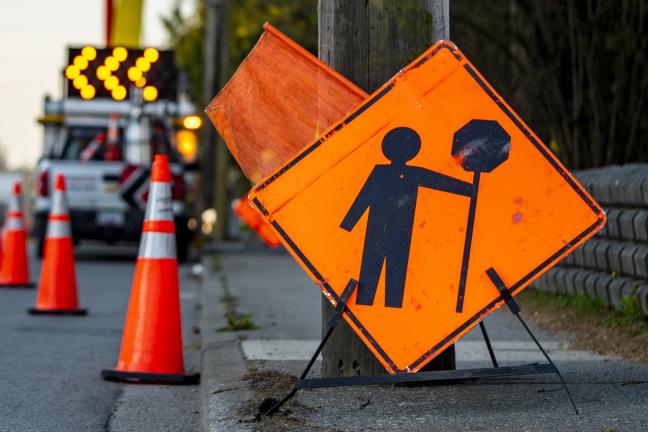 an orange construction sign indicating stop ahead