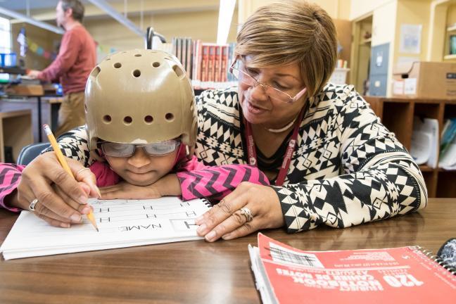 Foster grandparent works on school work with second grader.