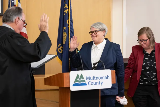 Commissioner Meghan Moyer is sworn in by retired Justice Paul de Muniz on Jan. 6, 2025, in the Multnomah County Boardroom.