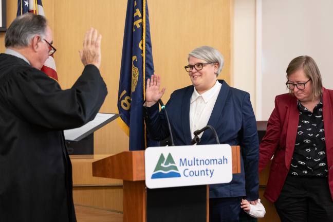 Commissioner Meghan Moyer is sworn in by retired Justice Paul de Muniz on Jan. 6, 2025, in the Multnomah County Boardroom.