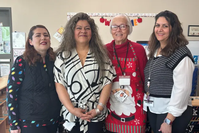 Teachers and foster grandparent pose for a picture.