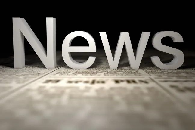 The word News sitting on newspaper print