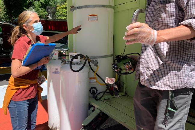 Inspecting a water tank at a food cart.