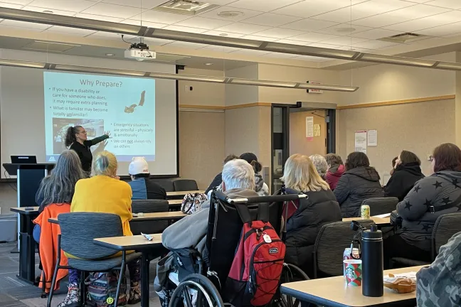 County employee shows members of the audience emergency management training information on a powerpoint slide.