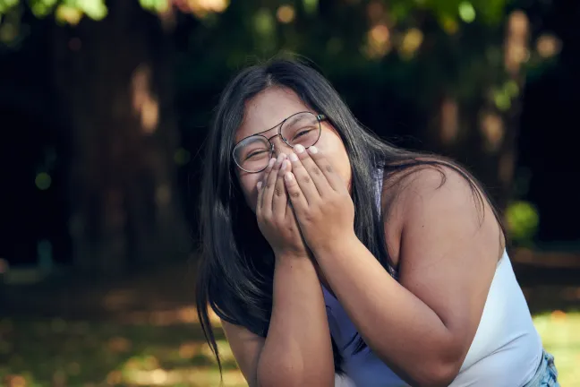 Youth laughing and cover face from excitement