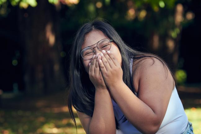 Youth laughing and cover face from excitement