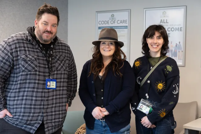 Three people standing next to each other in a room