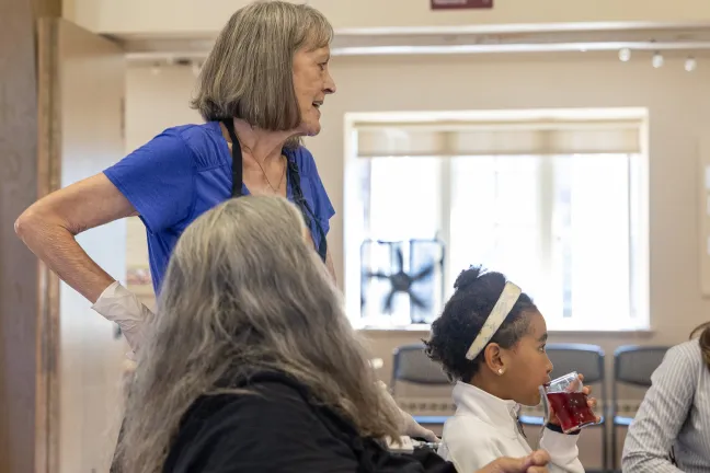 A medium shot captures three people in what looks like a community center.