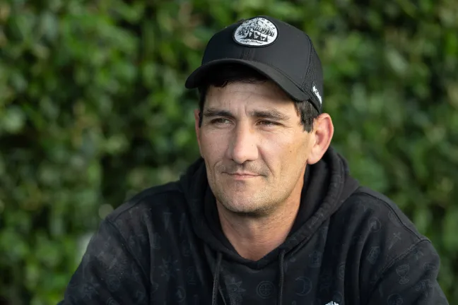 Wes sits outside and looks off into distance