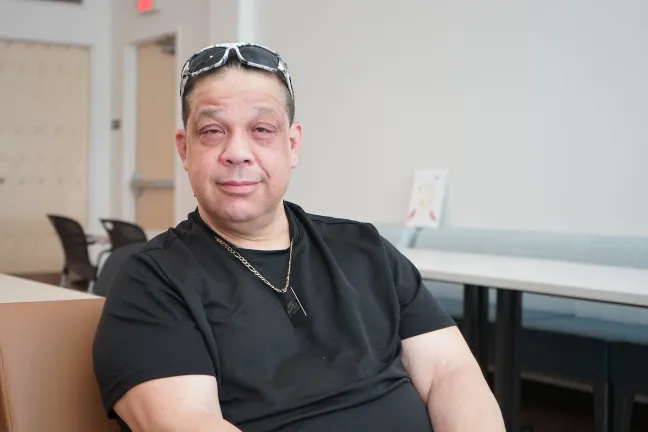 Ricky sits and smiles