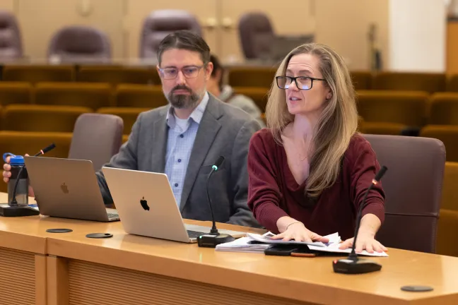 Jillian Schoene and Ryan Deibert sit at the dais in the Multnomah County boardroom.