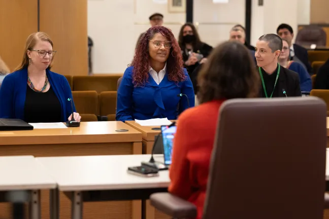 Three speakers seated present before the Board. 