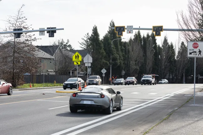 A car driving down 257th under the flashing beacon signals.