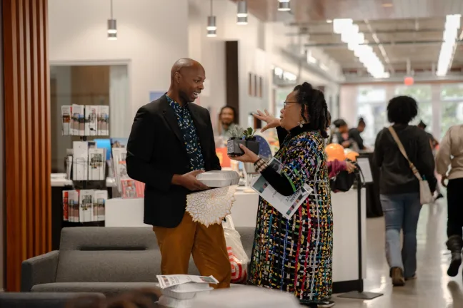 Dr. Deron Cole speaking with a woman 