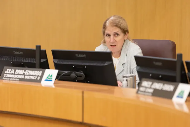 A close-up of Commissioner Julia Brim-Edwards speaking during the Board meeting. She is seated behind a nameplate that reads "Julia Brim-Edwards, Commissioner District 3."