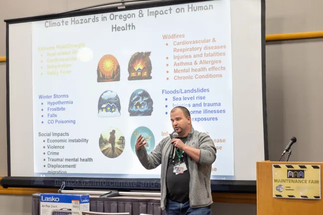 Un ponente en la Feria de Mantenimiento habló sobre el impacto de los riesgos climáticos en la salud en Oregón. La diapositiva de la presentación destacó la relación entre los fenómenos meteorológicos extremos, como incendios forestales e inundaciones, y los riesgos para la salud humana.