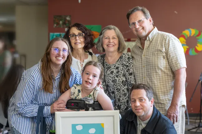 An artist and her family at the 2025 IDDSD Art Reception at Five Oak.