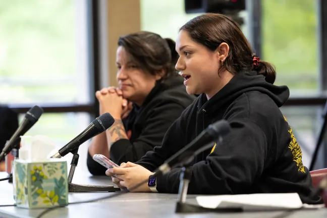 Image of a community member at a desk testifying