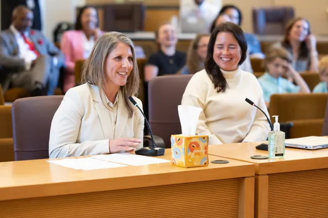 Rachel Pearl and Sara Morrissey sit at dais