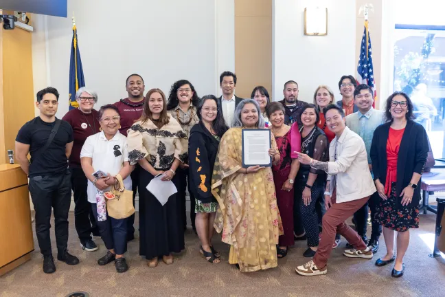 Board members, County staff and invited guests pose with the signed Asian American Pacific Islander Heritage Month proclamation in the boardroom.