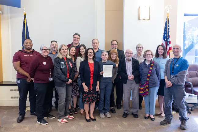 Board members, County staff and invited guests pose with the signed Burnside Bridge Centennial Birthday proclamation in the boardroom.