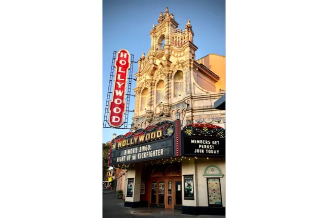 La fachada del Hollywood Theatre, que celebra su centenario en 2026. El letrero anuncia "B-MOVIE BINGO: NIGHT OF THE KICKFIGHTER" y "¡LOS MIEMBROS TIENEN VENTAJAS! ¡ÚNETE HOY!".