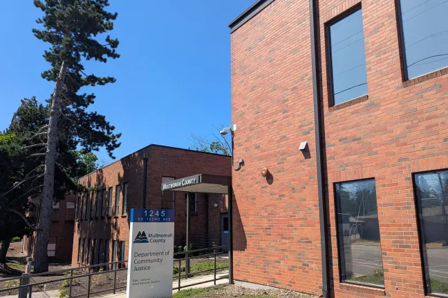 sign outside Community Justice's East Campus facility, showing part of building and identifying sign with DCJ name and logo