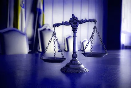 photo of scales of justice on table in courtroom