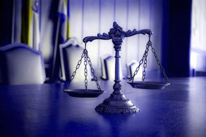 photo of scales of justice on table in courtroom