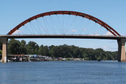 Sauvie Island bridge with river in the foreground, and houseboats and blue sky in the background.