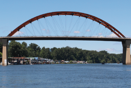 Sauvie Island bridge with river in the foreground, and houseboats and blue sky in the background.