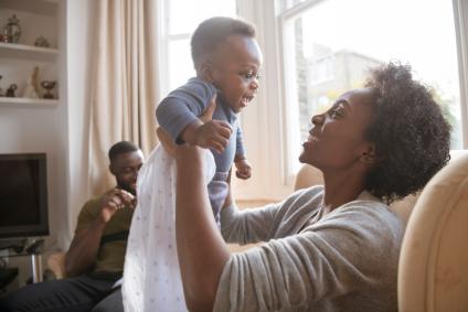 happy African American mom lifting her new baby
