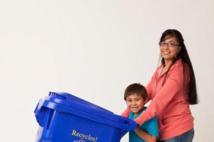 Woman and young child posing with a blue recycle bin.
