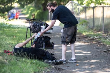 Outreach workers handing out water to unhoused people on June 28, 2021.