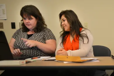Carmen Ruiz, second from left, signs up for health insurance at an application fair March 18.