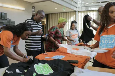 Members of the Oregon Association for Liberia sell t-shirts to raise money for Medical Teams International.