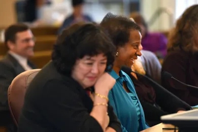 Mary Li (far left) and Kay Toran CEO of Volunteers of American Oregon (center) share a laugh at Tuesday's board meeting