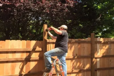 DCJ PPO on ladder while building fence