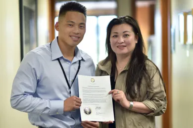 Sang Dao and his mother Mai Trinh hold up letter from former Governor Kitzhaber granting clemency. Dao began working for Multnomah County shortly after he was released from prison. 