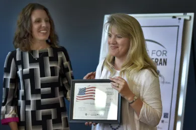 Debi Christiansen, senior portfolio manager with PCRI accepts award from Chair Deborah Kafoury on behalf of her organization’s work housing homeless Veterans.