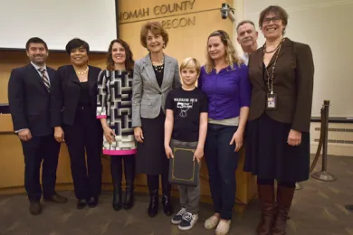 Kadin Patterson and his family pose with the Board of Commissioners during Thursday's meeting.