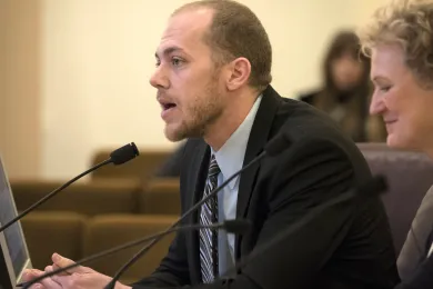 Deputy Government Relations Director Chris Fick addresses the board as Government Relations Director Claudia Black (right) looks on.