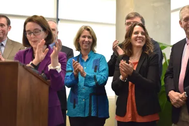 Gov. Kate Brown, State Rep Keny-Guyer and Chair Kafoury clap before ceremonial signing of affordable housing bills 