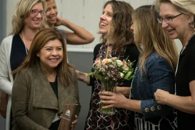Olivia Quiroz laughs as she holds the Rose CDC award